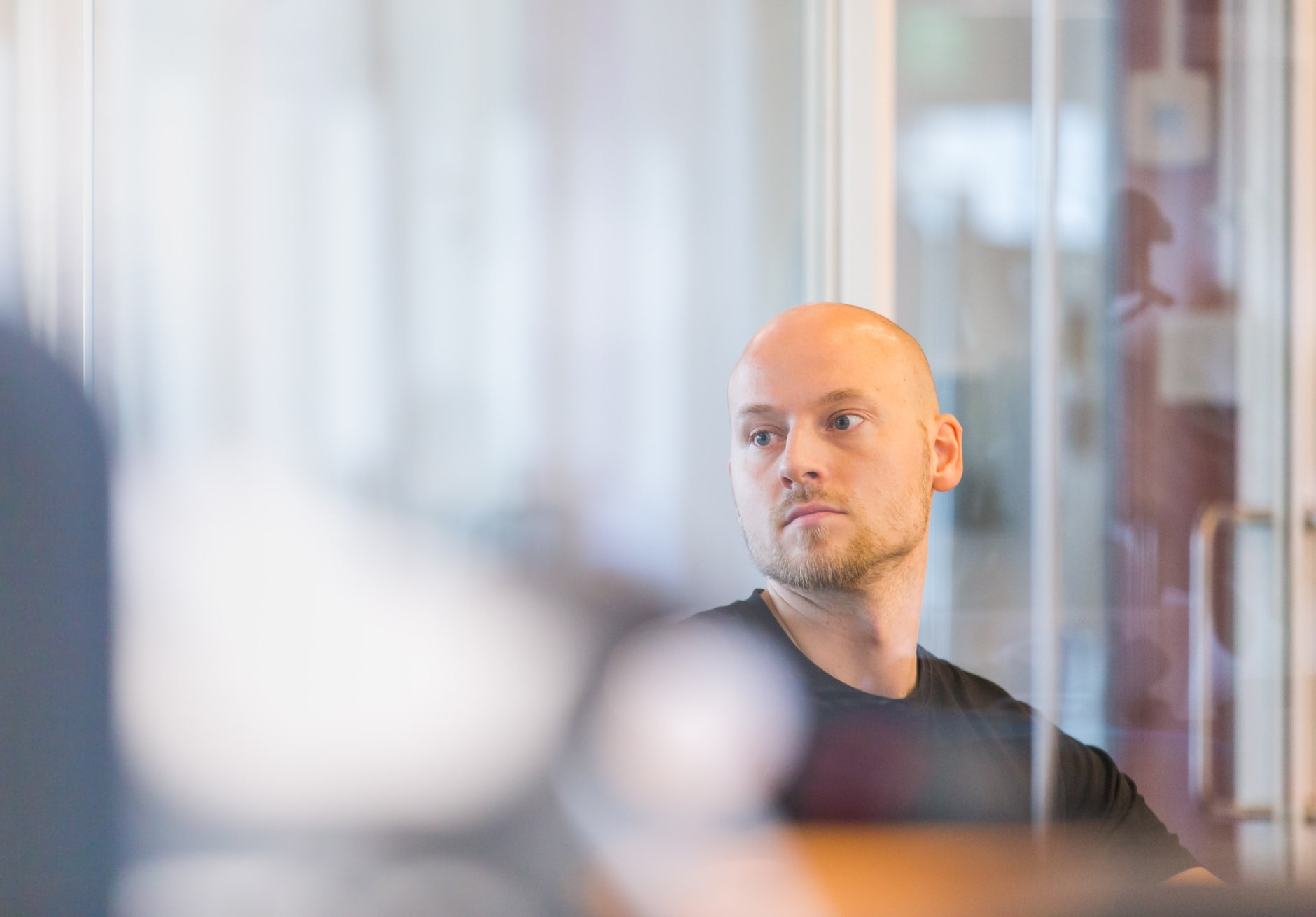 Kehittäjämme Mikko istuu työpöydän ääressä toimistolla tausta sumeana
